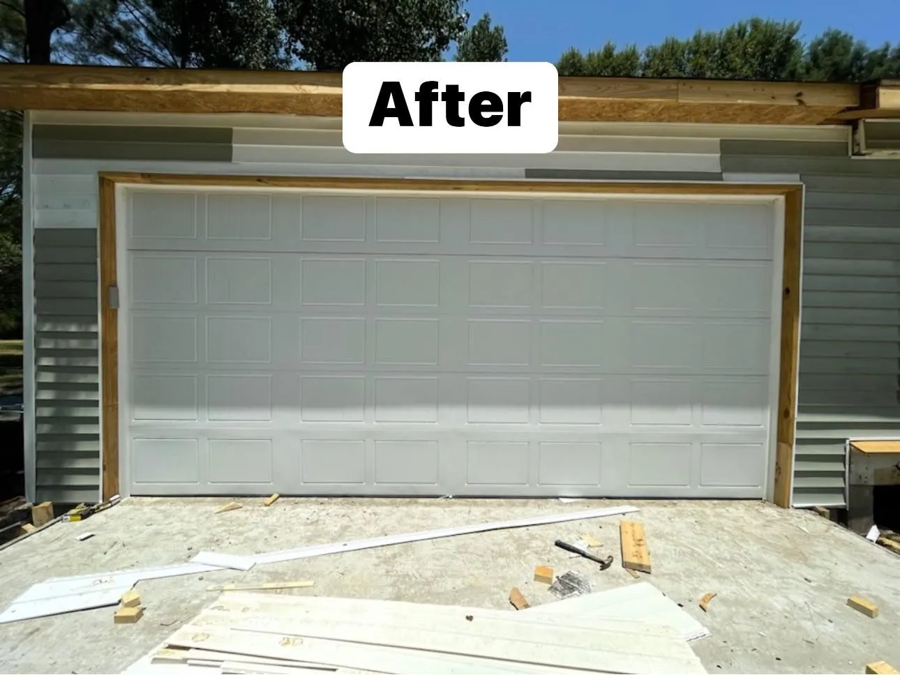 New black garage door installed on a metal building